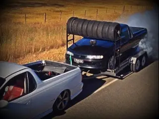 Una pick-up quemando rueda sobre el remolque de otra pick-up