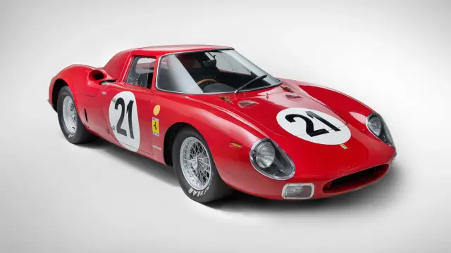 Vista frontal-lateral de un coche de carreras Ferrari 250 LM rojo clásico con el número 21, sobre un fondo neutro