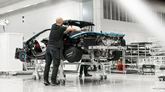 Un trabajador de McLaren ajusta un chasis de un deportivo en Woking
