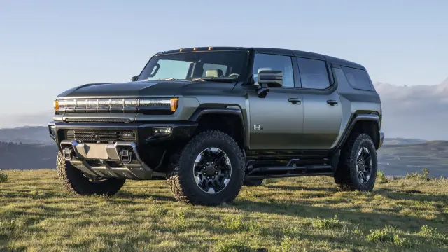 Front 3/4 shot of 2024 GMC HUMMER EV SUV in Moonshot Green Matte overlooking mountain vista.