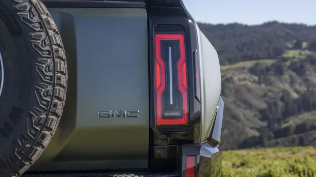 Close-up of rear passenger-side taillight on 2024 GMC HUMMER EV SUV parked at off-road mountain vista.